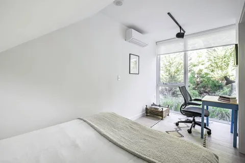 a bedroom with a bed a table and a large window