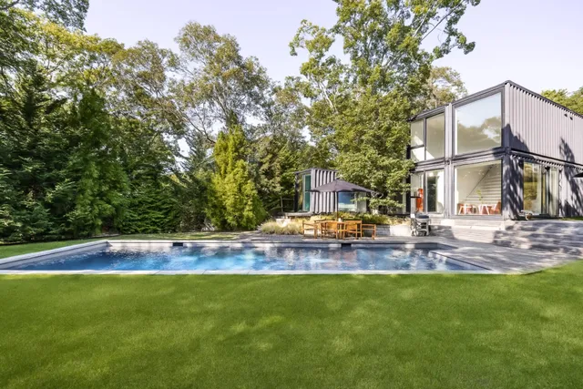 a view of swimming pool with lawn chairs and plants