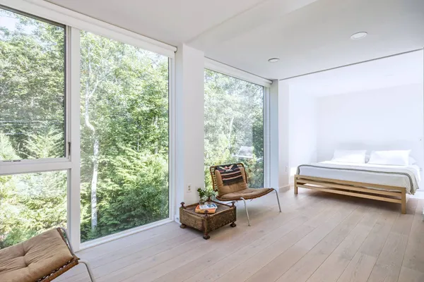 a bedroom with a bed and large windows