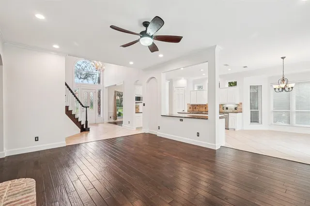 a view of a livingroom with wooden floor and a ceiling fan