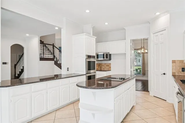 a kitchen with granite countertop a sink stainless steel appliances and cabinets