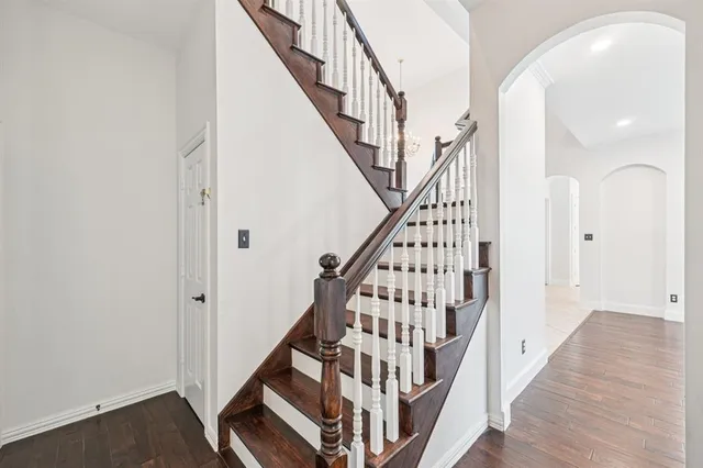a view of staircase with wooden floor and white walls