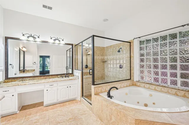 a bathroom with a bathtub a double vanity sink a toilet a mirror and shower