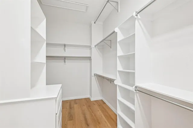 a view of walk in closet with empty racks