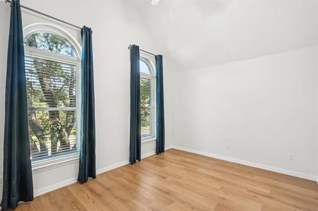 a view of a room with wooden floor and windows