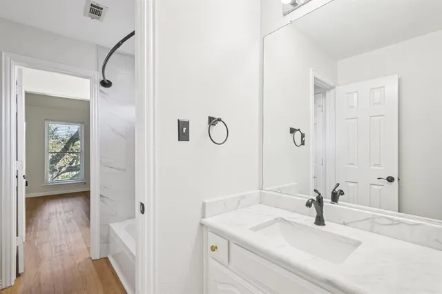 a bathroom with a sink vanity granite and a mirror