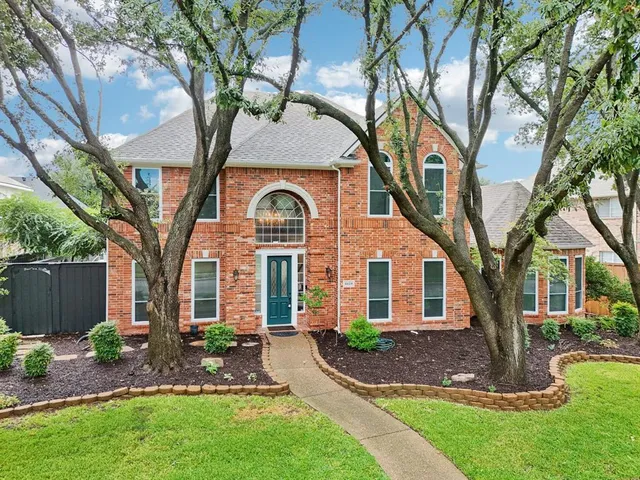 a front view of a house with yard and green space