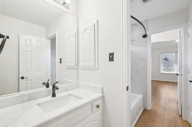 a bathroom with a tub sink and mirror