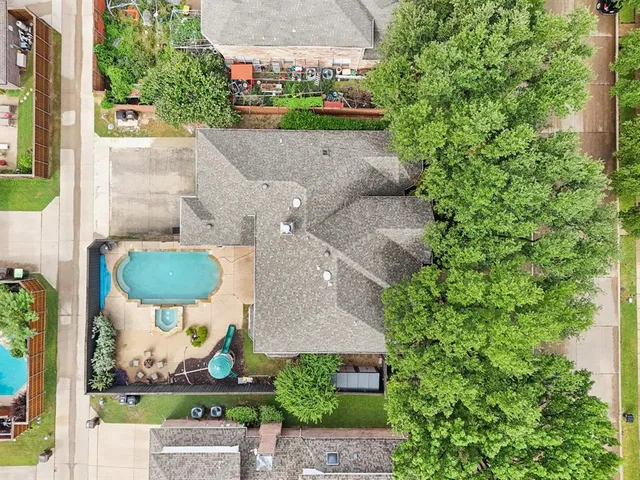 an aerial view of a house with garden space and a patio