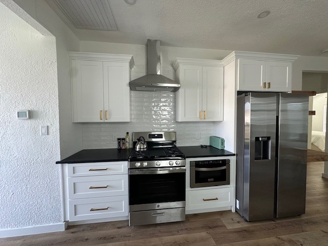1311 East 35th Street Houston, TX 77022 - Photo 4 of 12 a kitchen with white cabinets and stainless steel appliances