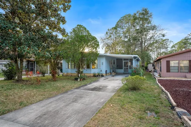 a front view of a house with a yard and potted plants