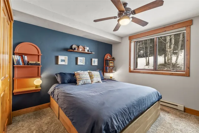 a bedroom with a bed and a painting on the wall