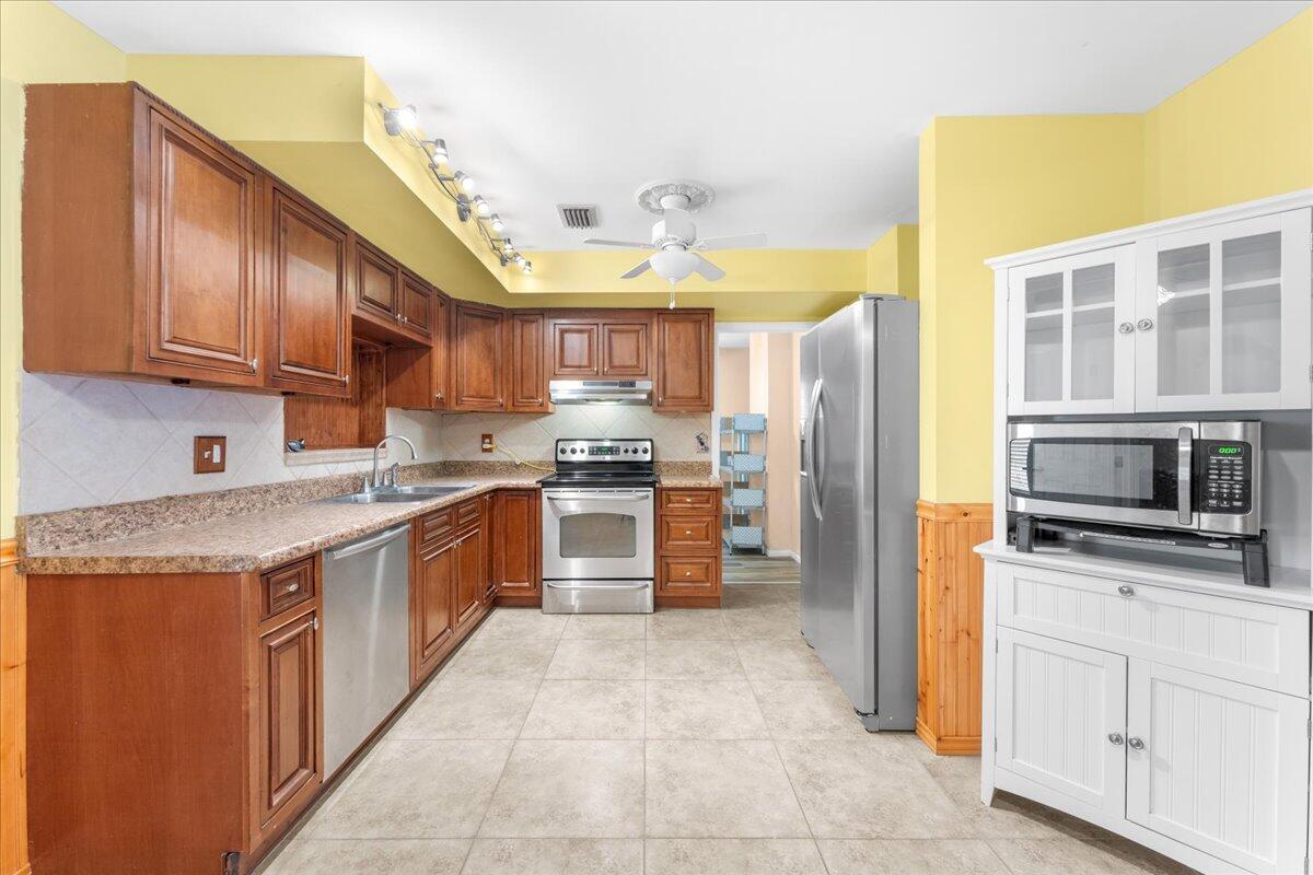 2199 Fatzler Road Melbourne, FL 32935 - Photo 11 of 23 a kitchen with stainless steel appliances granite countertop a stove top oven a refrigerator a sink and dishwasher