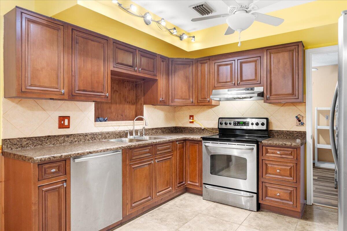 2199 Fatzler Road Melbourne, FL 32935 - Photo 12 of 23 a kitchen with stainless steel appliances granite countertop a stove sink and cabinets