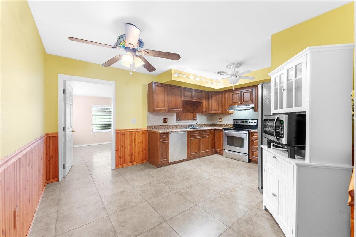 2199 Fatzler Road Melbourne, FL 32935 - Photo 10 of 23 a kitchen with kitchen island granite countertop a sink counter top space appliances and cabinets