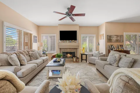 a living room with furniture a flat screen tv and a fireplace