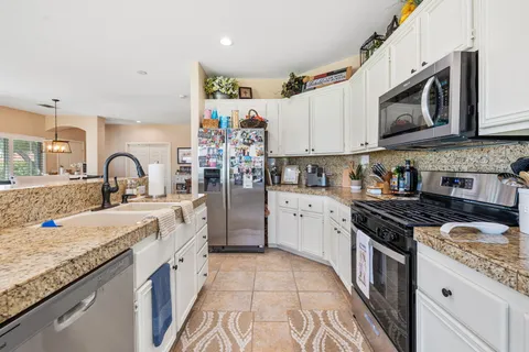 a view of kitchen with kitchen island stainless steel appliances a sink and living room view