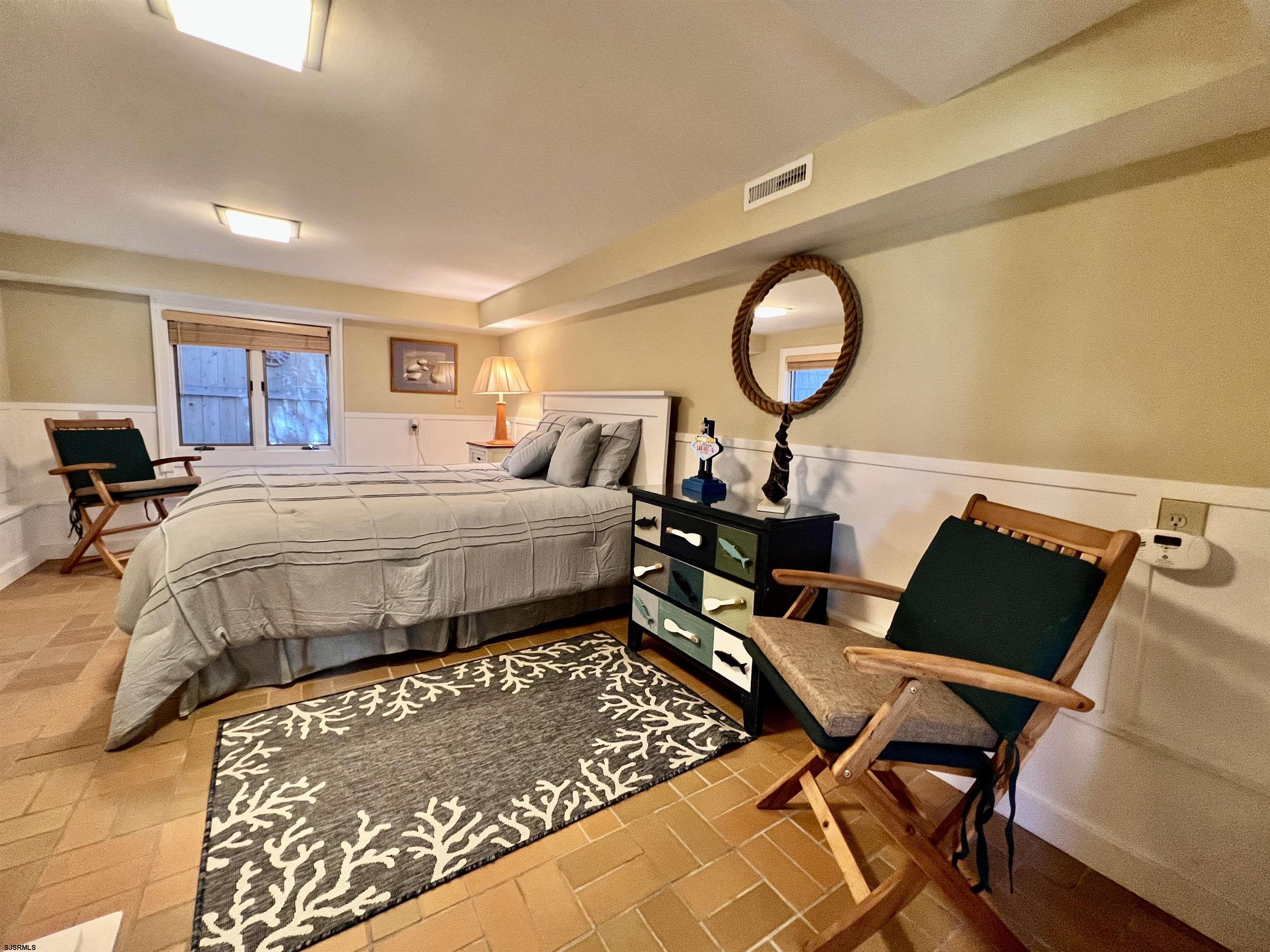 7 North Delavan Avenue, Unit MEMORIAL DAY LABOR DAY Margate City, NJ 08402 - Photo 14 of 60 a bedroom with a bed window and a table in it