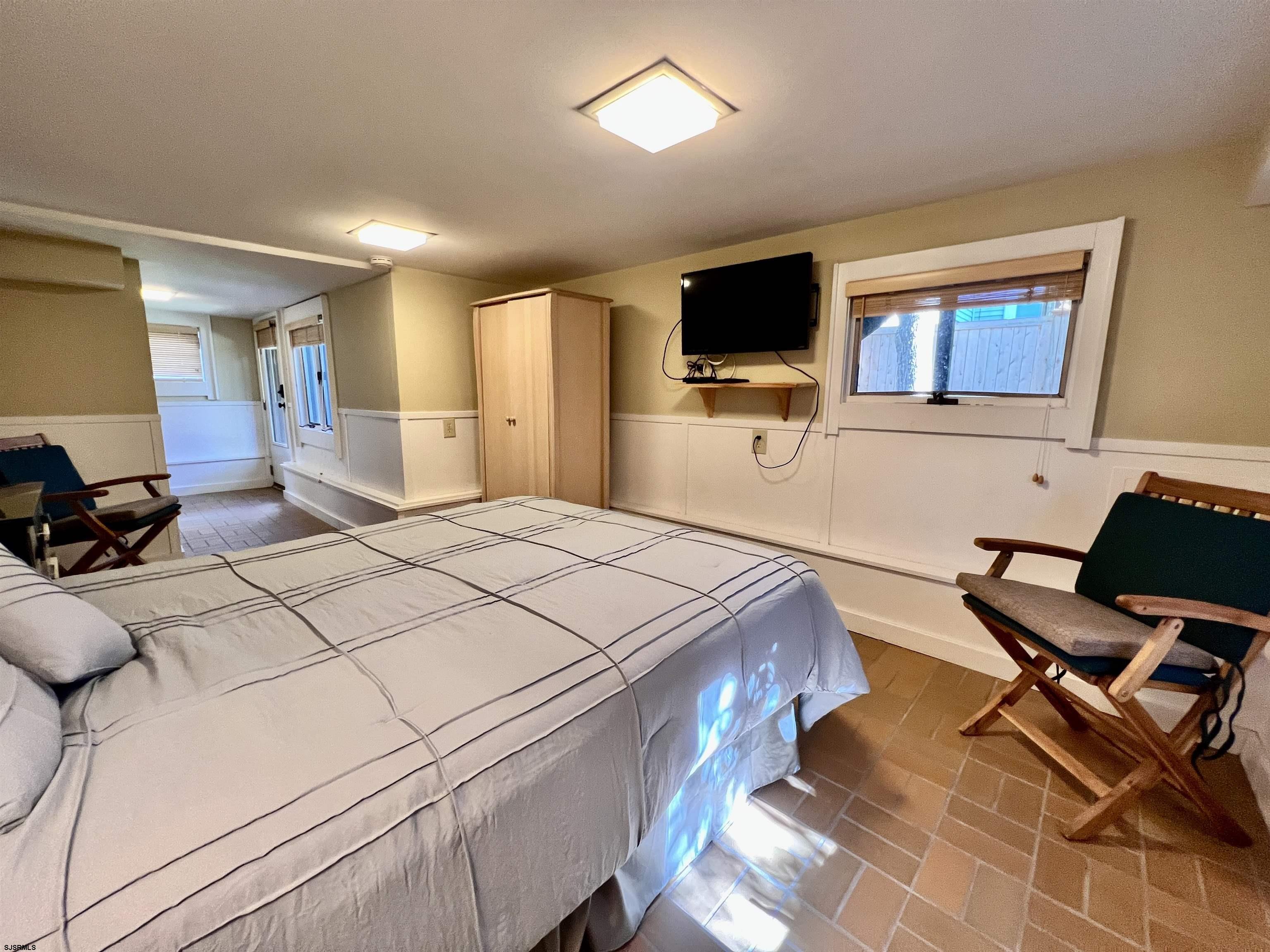 7 North Delavan Avenue, Unit MEMORIAL DAY LABOR DAY Margate City, NJ 08402 - Photo 16 of 60 a bedroom with a bed and a flat screen tv