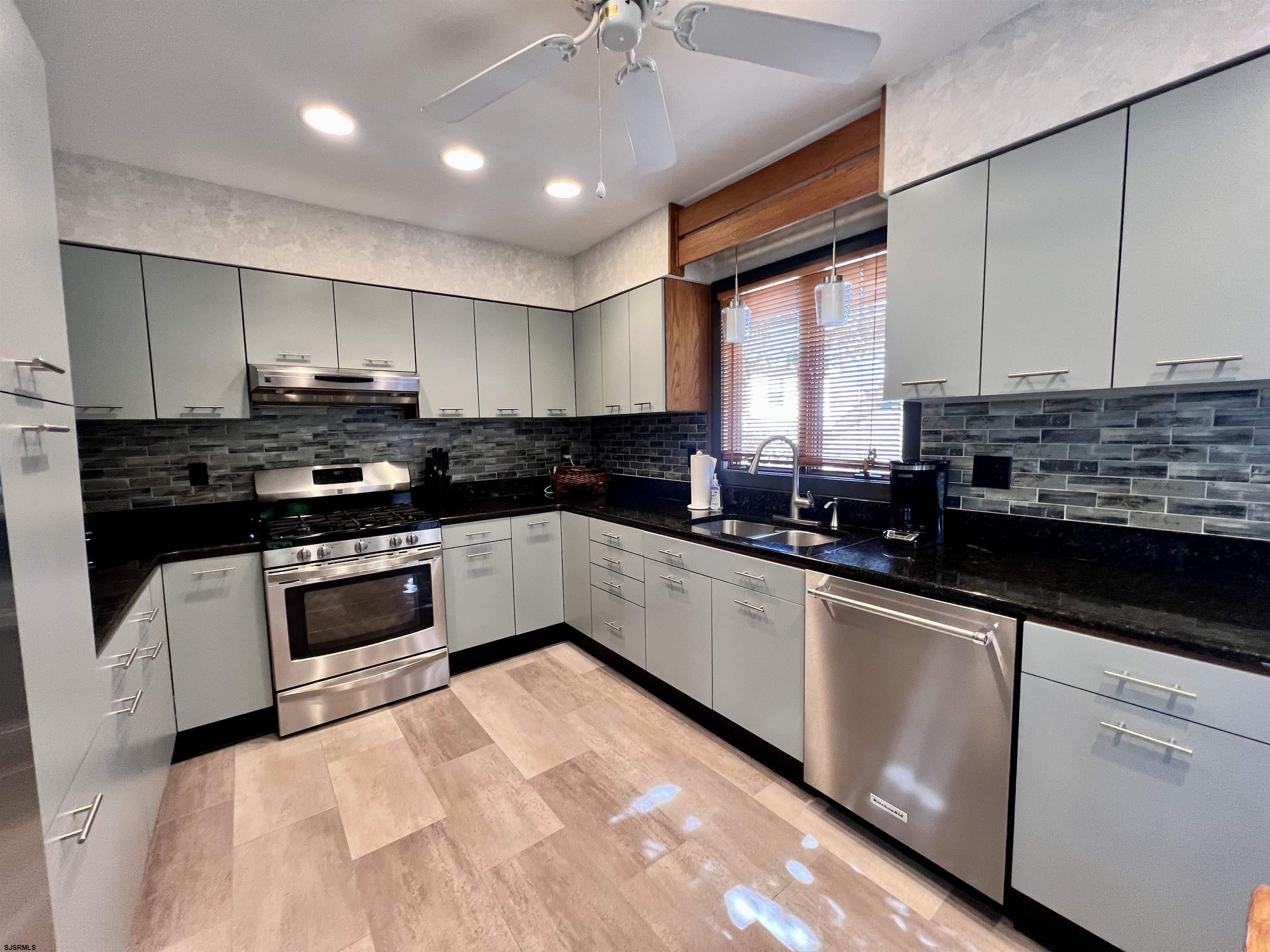 7 North Delavan Avenue, Unit MEMORIAL DAY LABOR DAY Margate City, NJ 08402 - Photo 27 of 60 a kitchen with stainless steel appliances kitchen island granite countertop a stove sink and cabinets