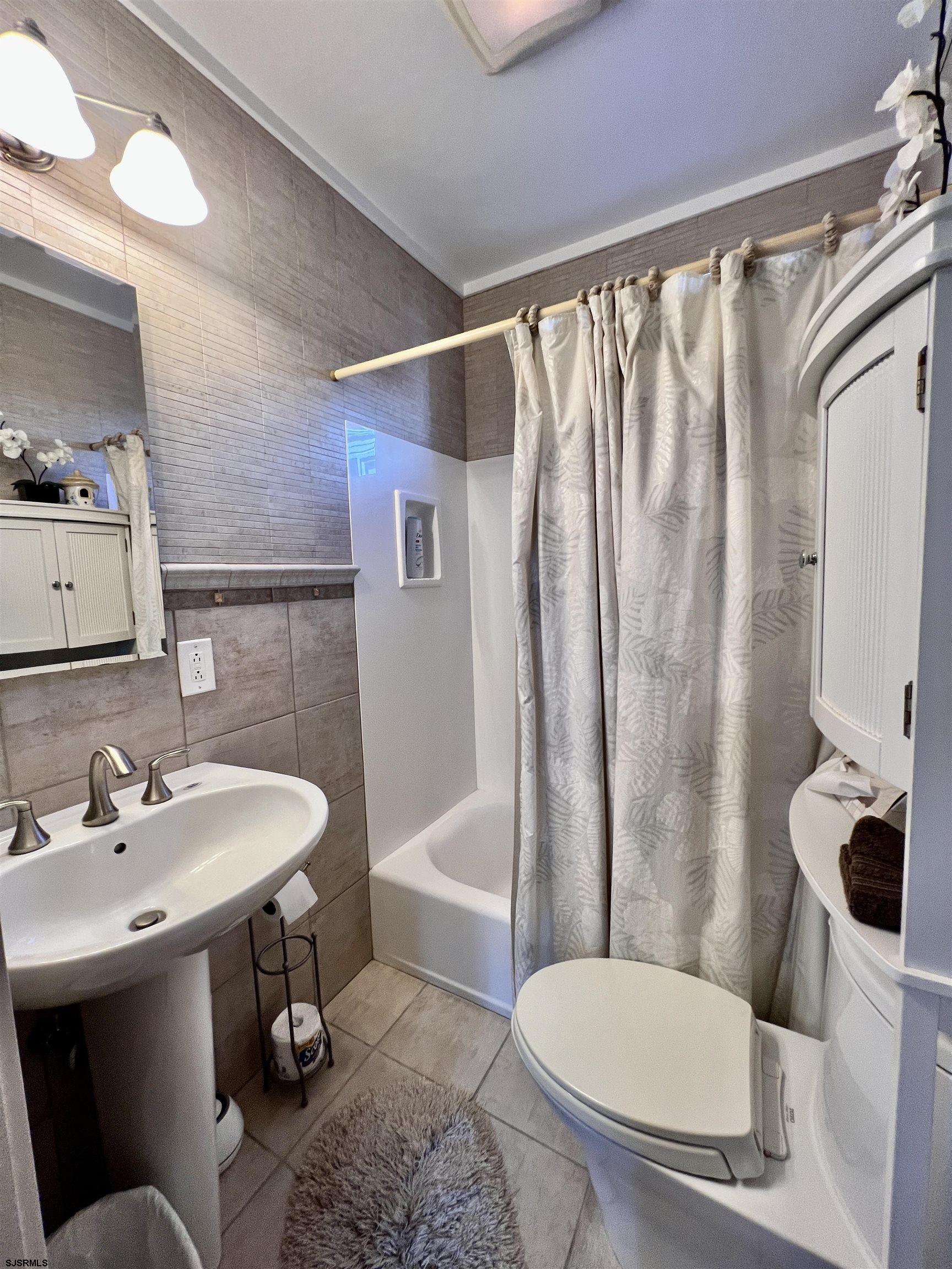 7 North Delavan Avenue, Unit MEMORIAL DAY LABOR DAY Margate City, NJ 08402 - Photo 36 of 60 a bathroom with a sink toilet and shower