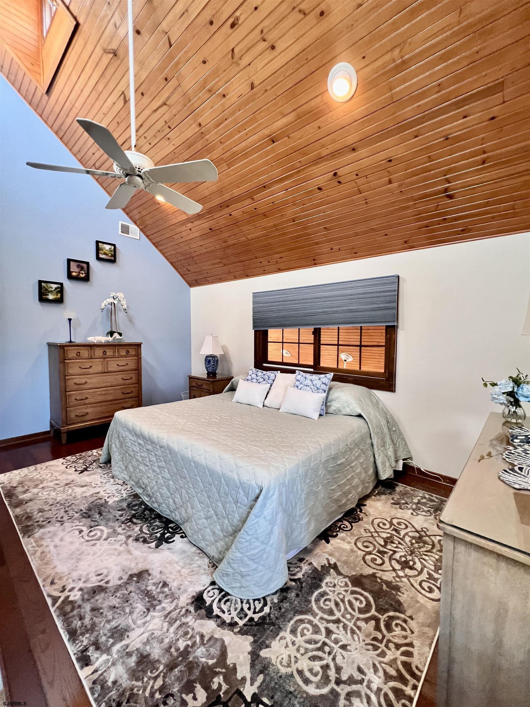 7 North Delavan Avenue, Unit MEMORIAL DAY LABOR DAY Margate City, NJ 08402 - Photo 40 of 60 a bedroom with a bed and wooden floor