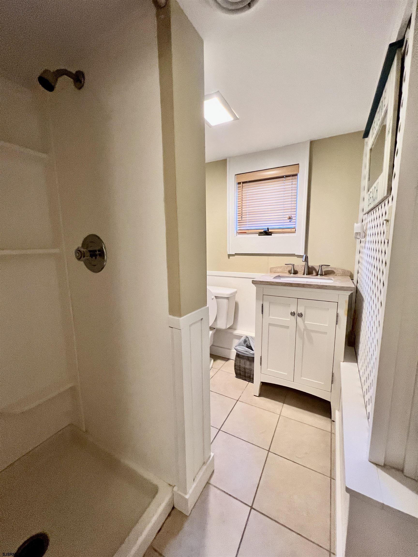 7 North Delavan Avenue, Unit MEMORIAL DAY LABOR DAY Margate City, NJ 08402 - Photo 8 of 60 a bathroom with a sink a toilet and shower