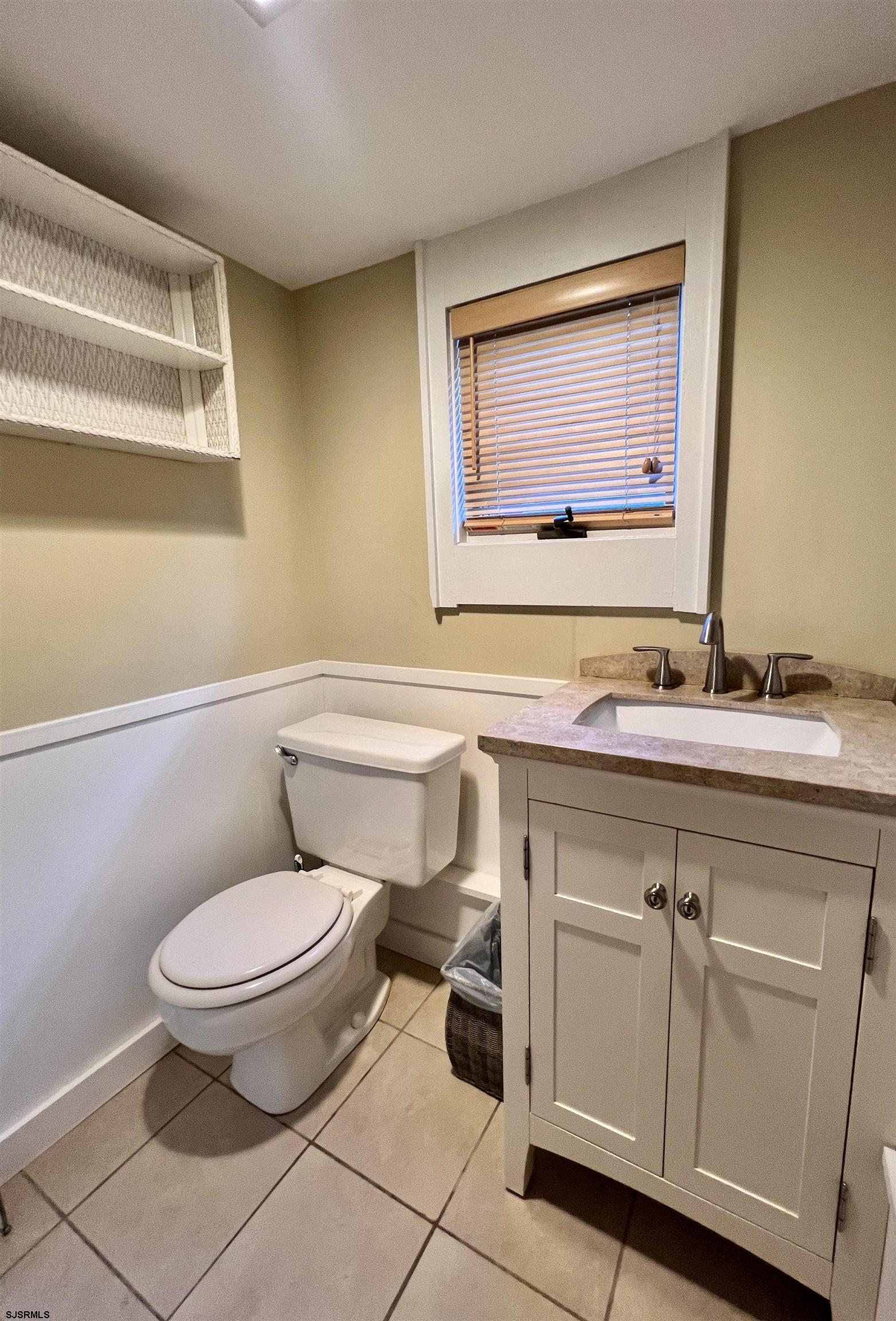 7 North Delavan Avenue, Unit MEMORIAL DAY LABOR DAY Margate City, NJ 08402 - Photo 9 of 60 a bathroom with a toilet a sink and a mirror
