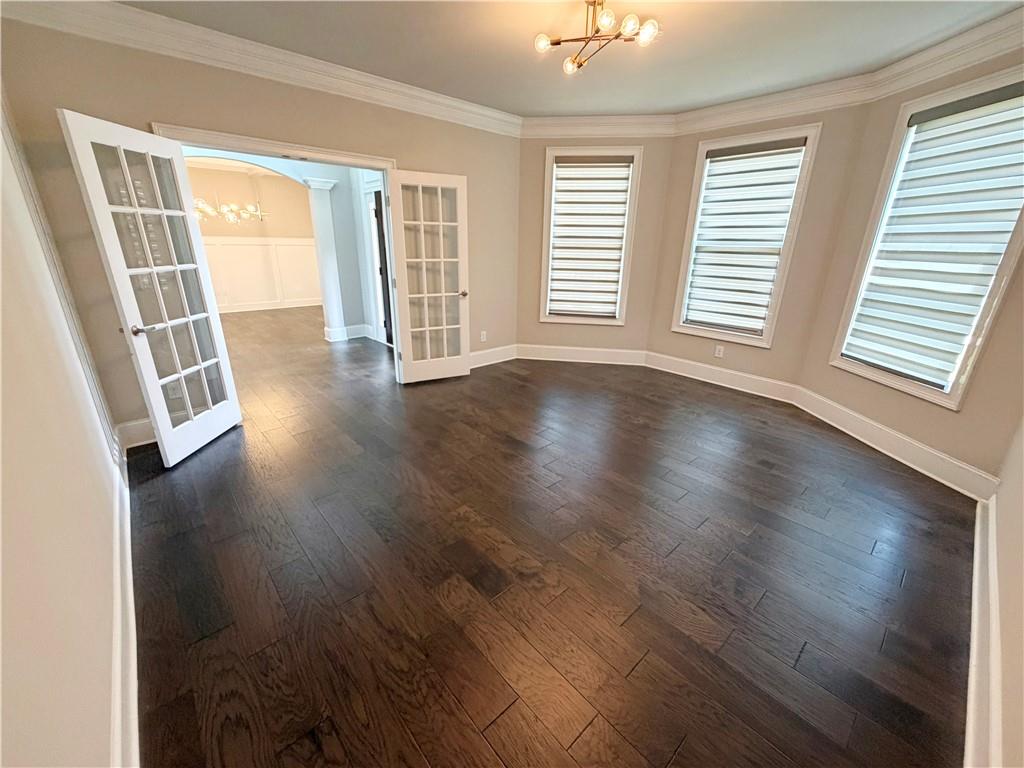 5296 Cheval Rue Court Suwanee, GA 30024 - Photo 6 of 51 an empty room with wooden floor and windows