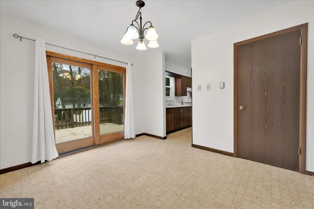 a view of an empty room with chandelier fan