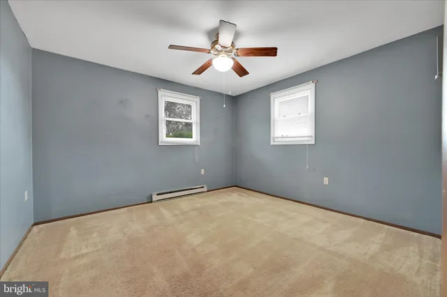 a view of an empty room and chandelier fan