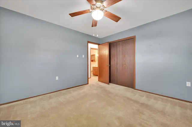 a view of an empty room with a chandelier fan