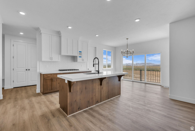2923 Scarlet Road, Unit 145 Eagle Mountain, UT 84005 - Photo 8 of 18 Open-concept kitchen and living area featuring custom ceiling height wood cabinets with crown molding, a large kitchen island and beautiful windows on all three sides of the dining area.