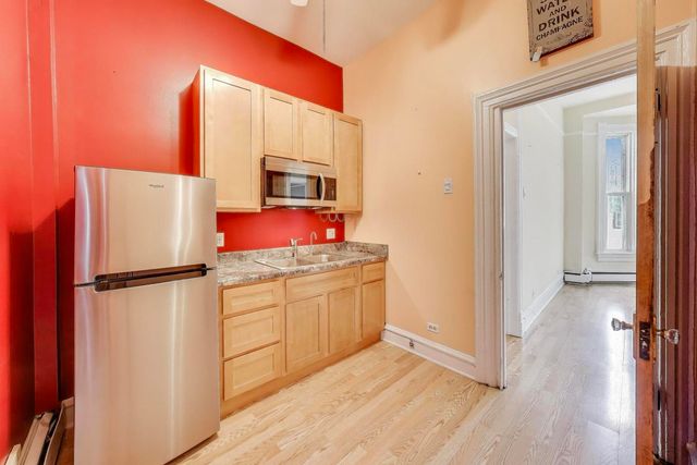a kitchen with appliances a refrigerator and a stove top oven
