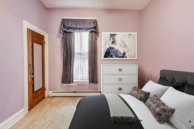 a bedroom with a bed and a painting on the wall