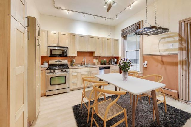 a kitchen with kitchen island a stove a table and chairs in it