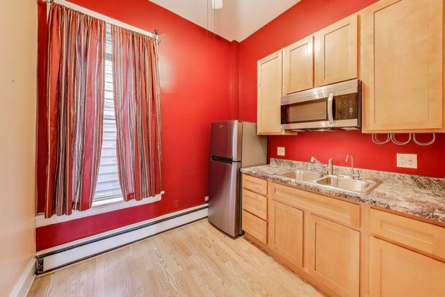 a kitchen with stainless steel appliances wooden cabinets and a microwave oven