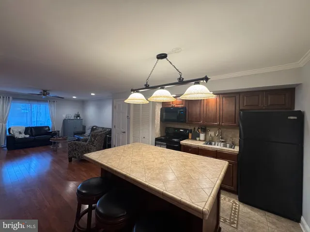 a kitchen with a table chairs a refrigerator and a stove