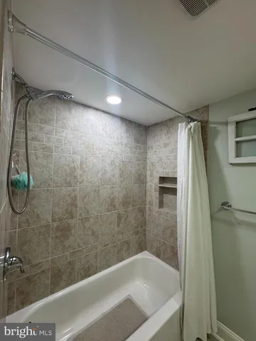 a bedroom with a bed a window and flat screen tv