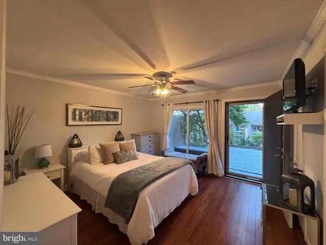 a bedroom with a bed and a large window with a flat tv screen