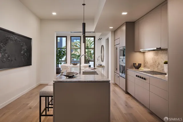 a kitchen with stainless steel appliances granite countertop a sink a stove and a refrigerator