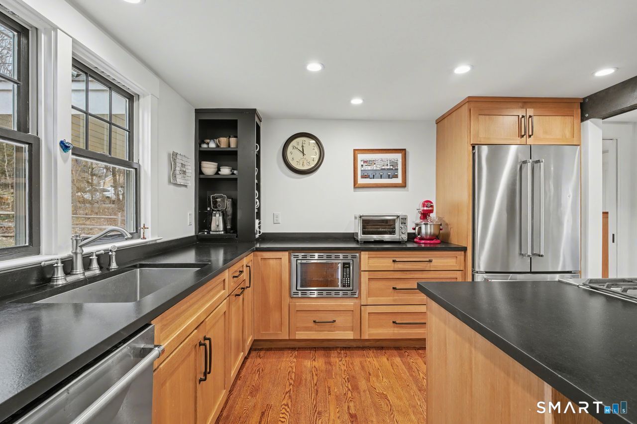 61 Bishop Lane Madison, CT 06443 - Photo 11 of 41 a kitchen with stainless steel appliances granite countertop a sink and a stove