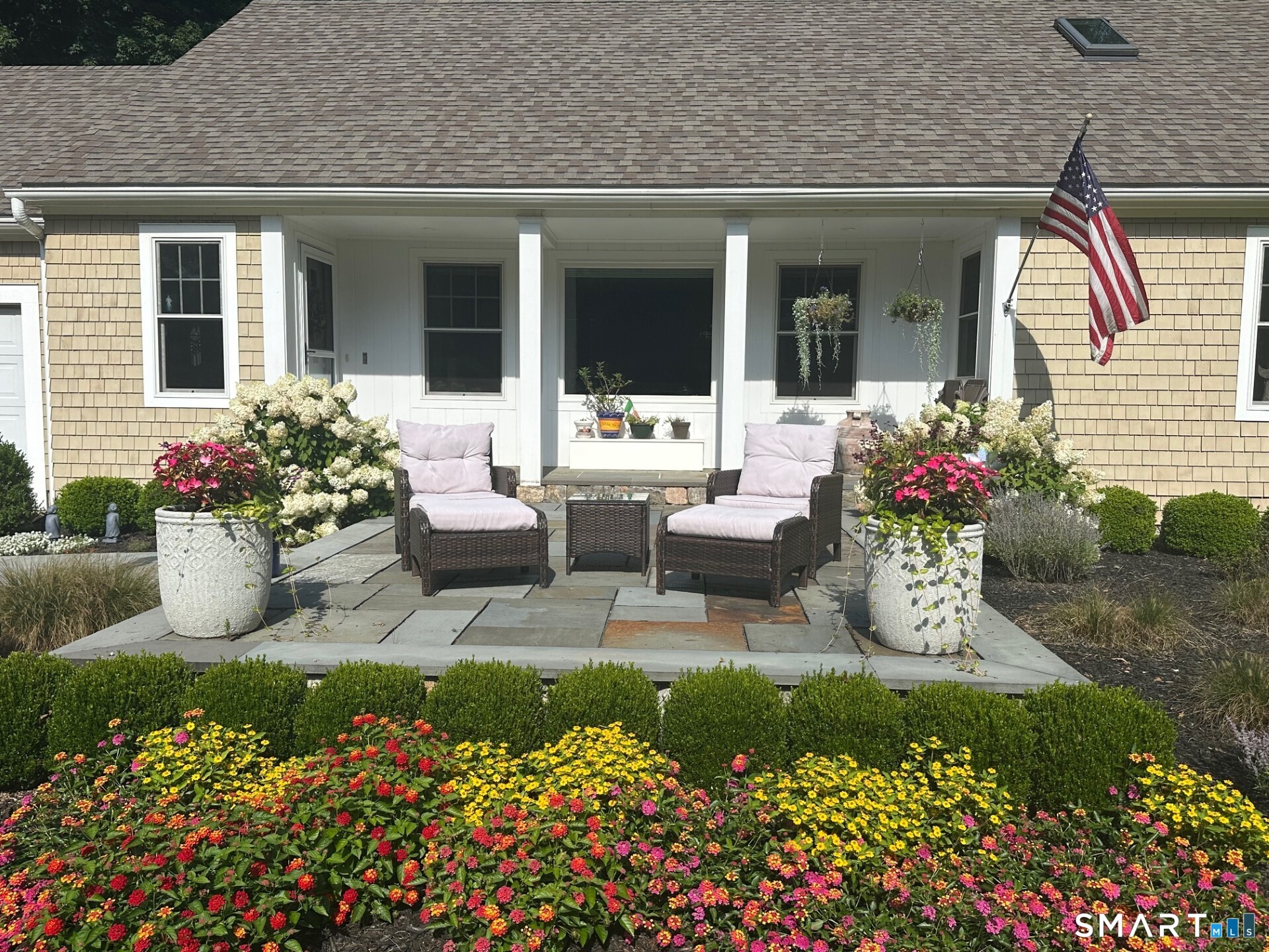 61 Bishop Lane Madison, CT 06443 - Photo 2 of 41 a front view of a house with a yard and flowers