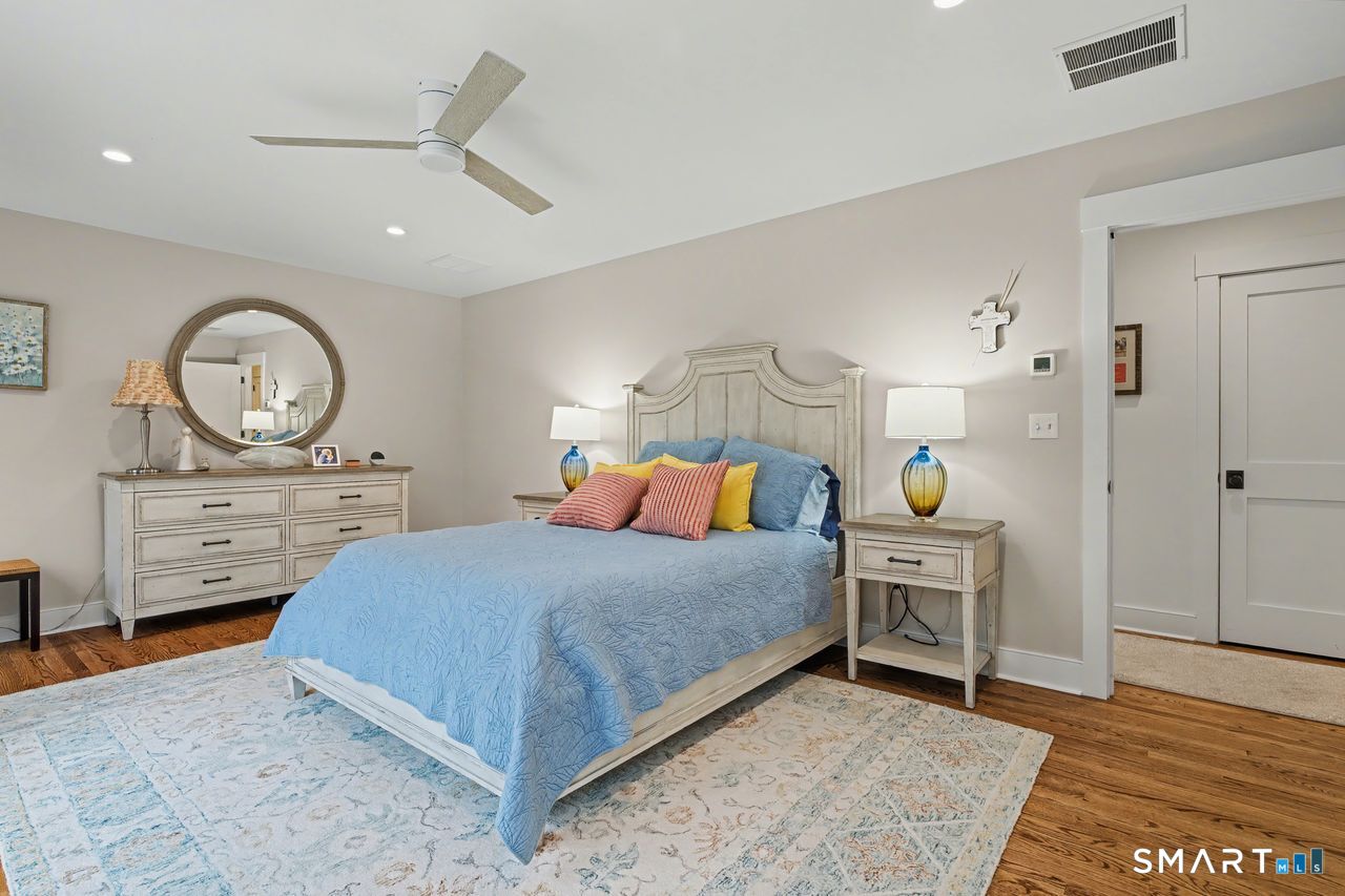 61 Bishop Lane Madison, CT 06443 - Photo 30 of 41 a bedroom with a bed a dresser and potted plants