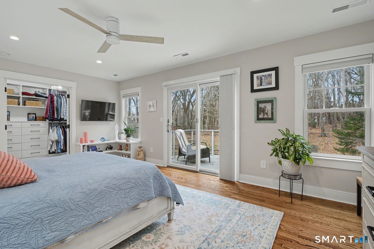 61 Bishop Lane Madison, CT 06443 - Photo 32 of 41 a spacious bedroom with a large bed and a potted plant