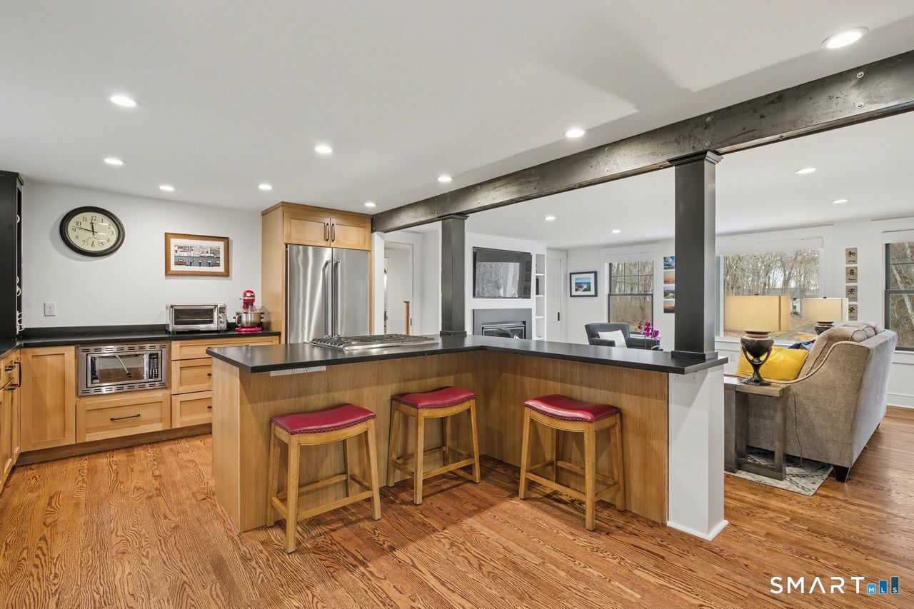 61 Bishop Lane Madison, CT 06443 - Photo 9 of 41 a large white kitchen with wooden floor and stainless steel appliances