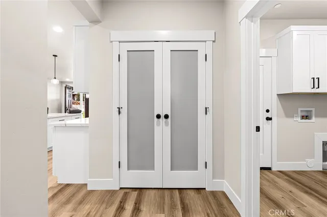 a view of a hallway with wooden floor and closet area