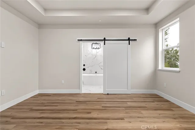 a view of a room with wooden floor and white walls