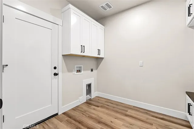 a view of a kitchen with cabinets and wooden floor