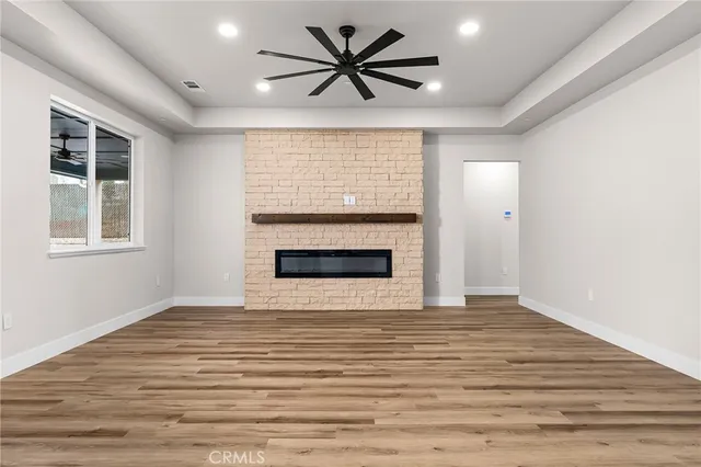 a view of an empty room with a window and a fireplace